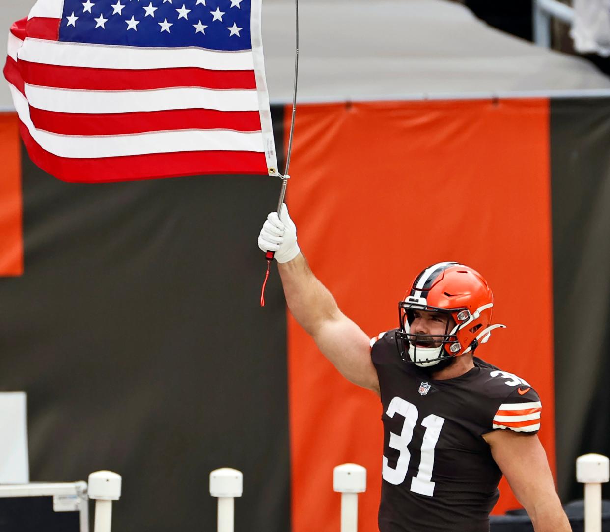 FILE - In this Nov. 15, 2020, file photo, Cleveland Browns running back Andy Janovich holds up a United States flag before an NFL football game against the Houston Texans in Cleveland. Janovich was placed on the COVID-list on Monday, Nov. 16, 2020, a day after he played in a win over the Texans. (AP Photo/Ron Schwane, File)