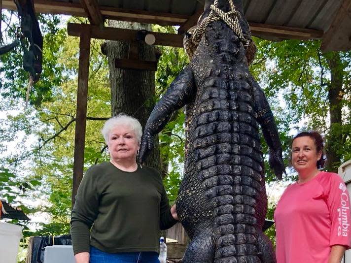 Judy Cochran (left) took one shot to kill the 580-pound ’gator: Scott Hughes