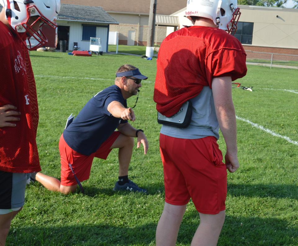 Head coach Erik Johnson runs a drill during a Britton Deerfield football practice this summer.