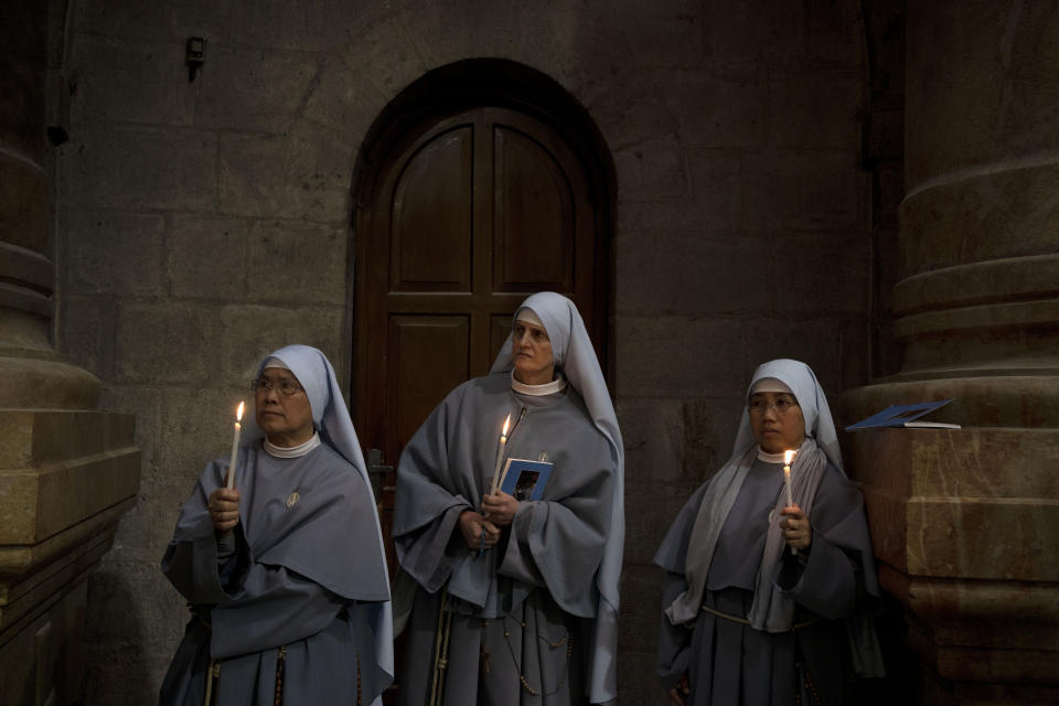 Catholic nuns hold candles during the Holy Thursday procession at the Church of the Holy Sepulcher, the site where according to tradition Jesus was crucified and buried, in the Old City of Jerusalem, Thursday, April 6, 2023. (AP Photo/Maya Alleruzzo)