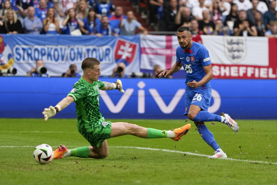 Slovakia's Ivan Schranz (26) scores past England's goalkeeper Jordan Pickford, left, during a round of sixteen match between England and Slovakia at the Euro 2024 soccer tournament in Gelsenkirchen, Germany, Sunday, June 30, 2024. (AP Photo/Matthias Schrader)