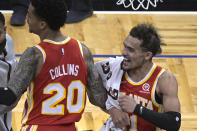 Atlanta Hawks forward John Collins (20) and guard Trae Young, right, celebrate the team's win over the Orlando Magic in an NBA basketball game Wednesday, March 3, 2021, in Orlando, Fla. (AP Photo/Phelan M. Ebenhack)