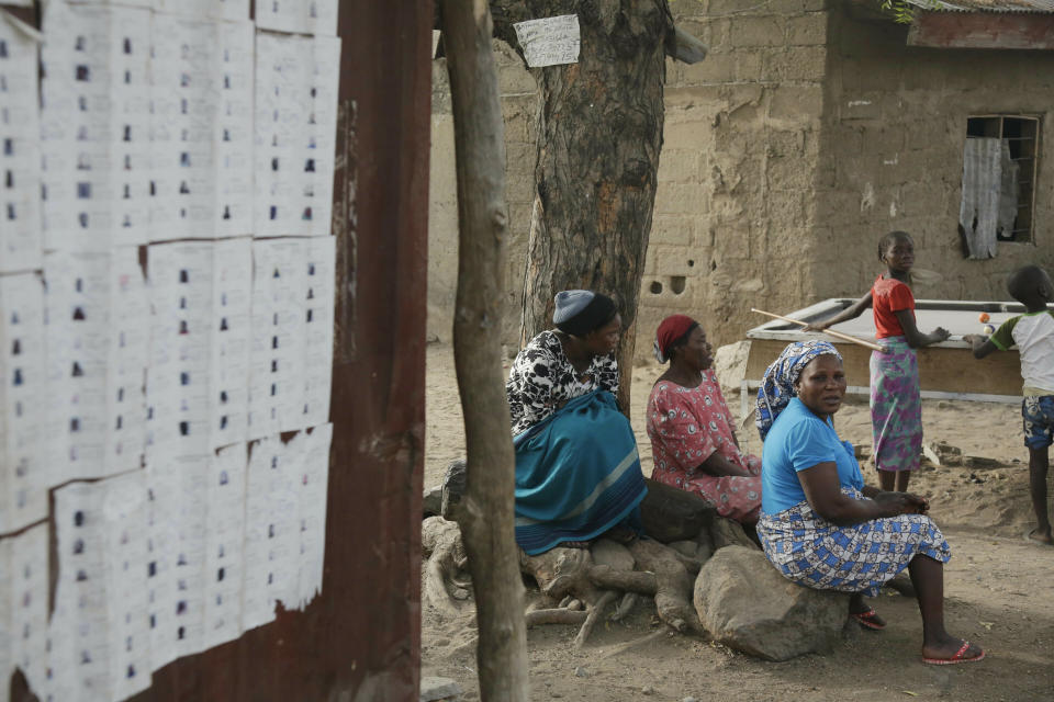 People wait sit outside a polling station following the presidential election being delayed by the Independent National Electoral Commission in Yola, Nigeria, Saturday, Feb. 16, 2019. A civic group monitoring Nigeria's now-delayed election says the last-minute decision to postpone the vote a week until Feb. 23 "has created needless tension and confusion in the country." (AP Photo/Sunday Alamba)