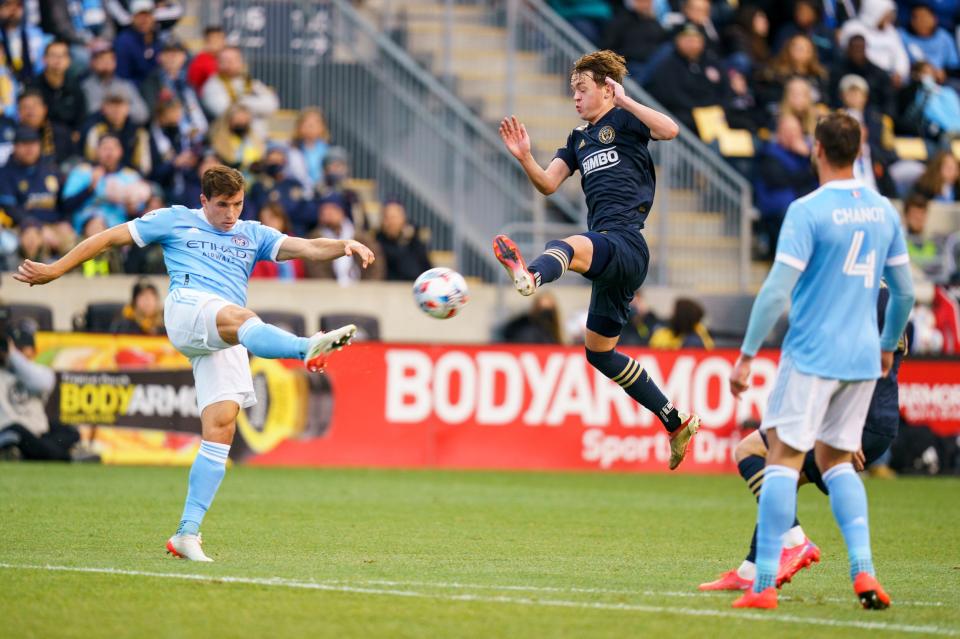 New York City FC's Malte Amundsen, left, kicks the ball upfield as Philadelphia Union's Jack McGlynn, center, leaps to try to block it during the first half of an MLS playoff soccer match, Sunday, Dec. 5, 2021, in Chester, Pa.