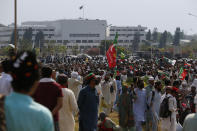 Supporters of Pakistan’s defiant former Prime Minister Imran Khan take part in an anti-government rally near parliament, background, in Islamabad, Pakistan, Thursday, May 26, 2022. Khan early Thursday warned Pakistan's government to set new elections in the next six days or he will again march on the capital along with 3 million people. (AP Photo/Anjum Naveed)