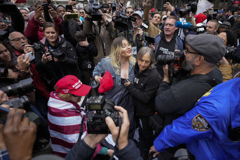 a crowd of protesters and reporters outside trump's arraignment argue with each other