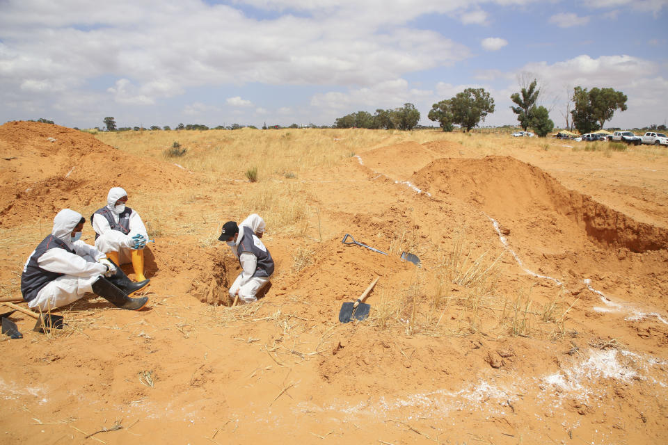 Libyan Ministry of justice employees dig out at a siyte of a suspected mass grave in the town of Tarhouna, Libya, Tuesday, June 23, 2020. The United Nations said that at least eight mass graves have been discovered, mostly in Tarhuna, a key western town that served as a main stronghold for Khalifa's east-based forces in their 14-month campaign to capture the capital, Tripoli. (AP Photo/Hazem Ahmed)