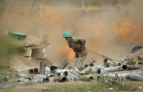 An Armenian serviceman fires a cannon towards Azerbaijan positions in the self-proclaimed Republic of Nagorno-Karabakh, Azerbaijan, Tuesday, Sept. 29, 2020. Armenian and Azerbaijani forces accused each other of attacks on their territory Tuesday, as fighting over the separatist region of Nagorno-Karabakh continued for a third straight day following the reigniting of a decades-old conflict. (Sipan Gyulumyan/Armenian Defense Ministry Press Service/PAN Photo via AP)