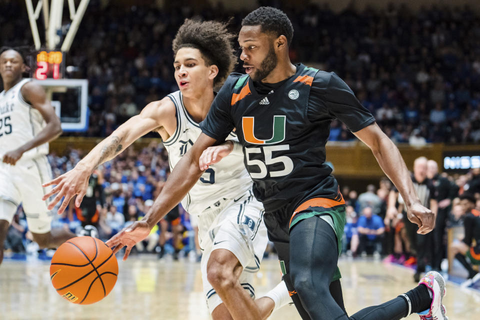 Miami guard Wooga Poplar (55) drives to the basket while guarded by Duke guard Tyrese Proctor (5) in the first half of an NCAA college basketball game on Saturday, Jan. 21, 2023, in Durham, N.C. (AP Photo/Jacob Kupferman)