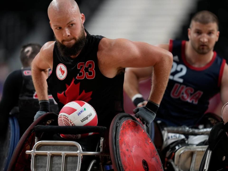 Zak Madell of Canada moves a ball during a wheelchair rugby pool phase group match against the U.S. at the Tokyo 2020 Paralympic Games on Thursday, Aug. 26, 2021. (Shuji Kajiyama/The Associated Press - image credit)