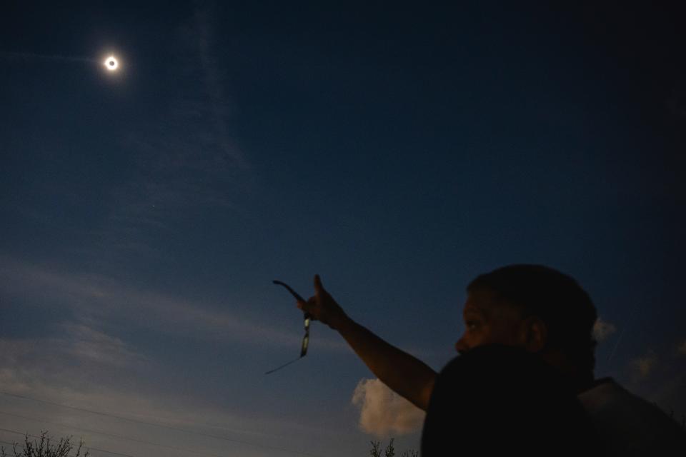 A newlywed couple looks up at a total solar eclipse during a mass wedding ceremony