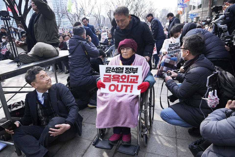 Yang Geum-deok, a South Korean victim of Japan's wartime forced labor, arrives at a rally against the South Korean government's move to improve relations with Japan in Seoul, South Korea, Wednesday, March 1, 2023. South Korea's president on Wednesday called Japan "a partner that shares the same universal values" and renewed hopes to repair ties frayed over Japan's colonial rule of the Korean Peninsula. The banner reads "South Korean President Yoon Suk Yeol's humiliation diplomacy." (AP Photo/Ahn Young-joon)