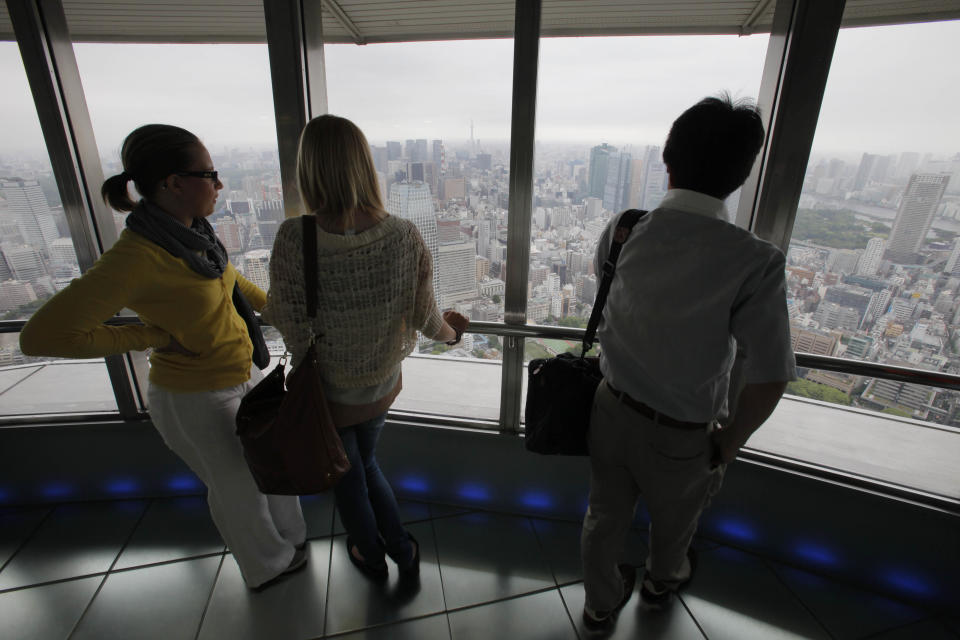 This photo taken Tuesday, June 12, 2012 shows visitors on the observation deck of Tokyo Tower in Japan. The Tokyo tourist experience is more affordable than the perception of an expensive city might suggest. Admission to the Tokyo Tower is only $10 and a visit to the Sensoji Temple, an important cultural site, is free. (AP Photo/Itsuo Inouye)