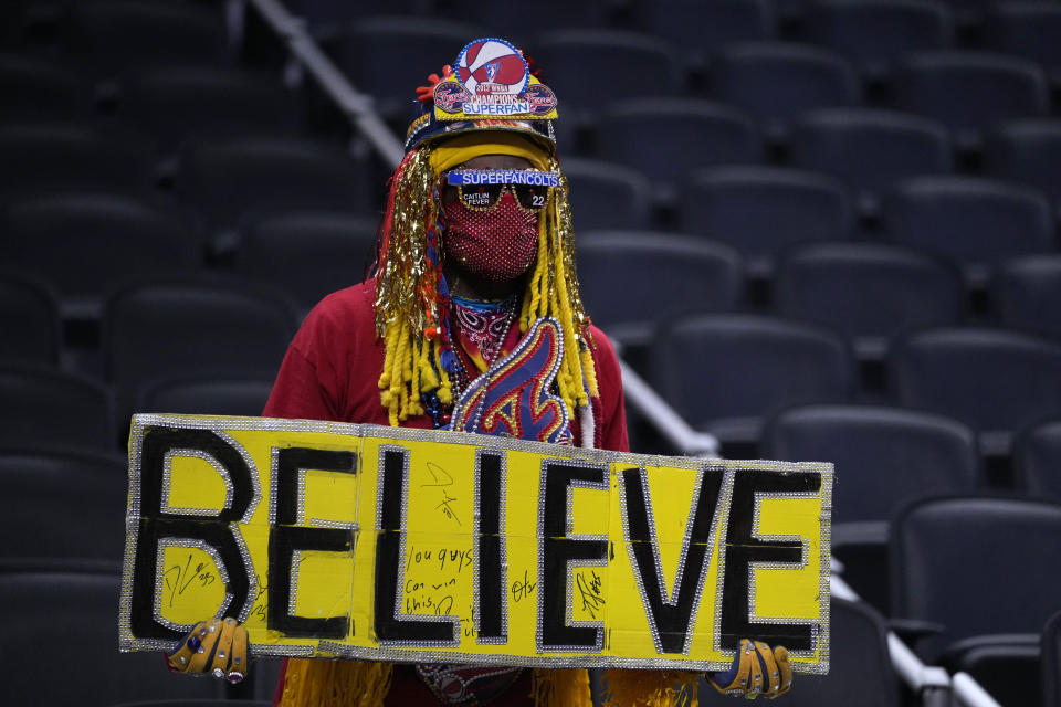 A person watches Indiana Fever guard Caitlin Clark warm up for the team's basketball game against the New York Liberty, Thursday, May 16, 2024, in Indianapolis. (AP Photo/Michael Conroy)
