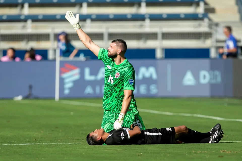 Canada goalkeeper Maxime Crépeau calls for help after an assistant referee collapsed during their match Tuesday in Kansas City. (Nick Tre. Smith/Icon Sportswire via Getty Images)