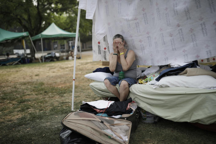 <p>Starla Davis cries as she packs a suitcase in her makeshift tent at an evacuation center Thursday, Aug. 9, 2018, in Redding, Calif. (Photo: John Locher/AP) </p>