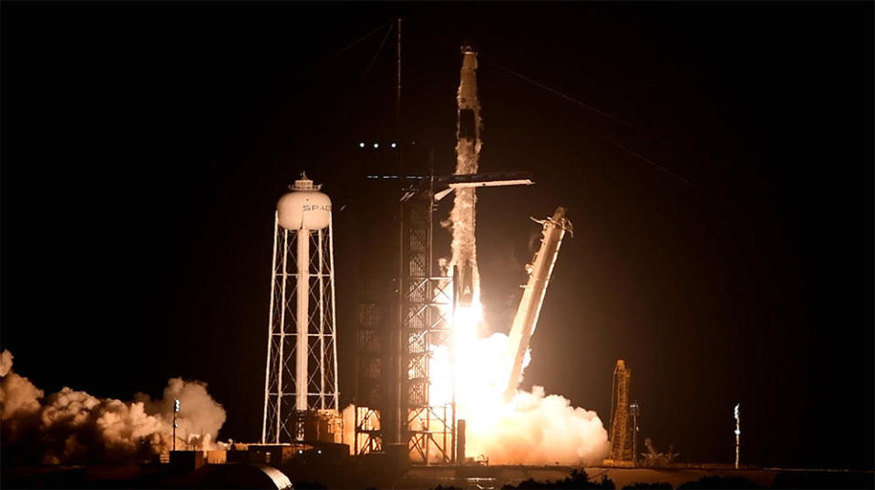 A  SpaceX Falcon 9 rocket carrying four astronauts in a Crew Dragon  capsule lights up the night sky with a brilliant jet of flame as its  nine first stage engines begin the climb to orbit. It was the second  Falcon 9 launch in six days and the 16th so far this year. / Credit: William Harwood/CBS News