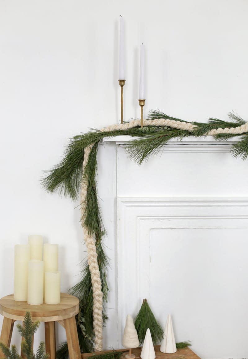 Fireplace decorated with winter greenery and white crochet braided garland