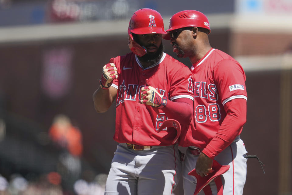 Los Angeles Angels' Luis Rengifo, left, reacts next to first base coach Bo Porter after hitting an RBI single against the San Francisco Giants during the seventh inning of a baseball game Saturday, June 15, 2024, in San Francisco. (AP Photo/Godofredo A. Vásquez)