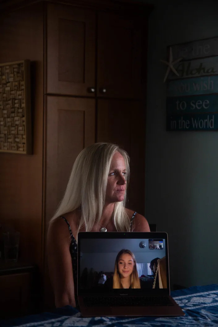 Carri Pothier sitting in her home in Ewa Beach, Hawaii, as her daughter, Abby Pothier, speaks by video from California, Oct. 11, 2022. (Marie Eriel Hobro/The New York Times)