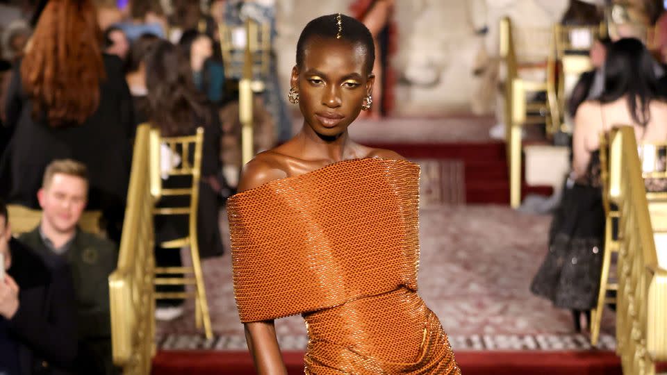 Body-conscious draped gowns in rich, burnt oranges represented the movies' desert landscapes; black "tinsel" fabrics nodded to the starry skies of deep space. - JP Yim/Getty Images for Christian Siriano