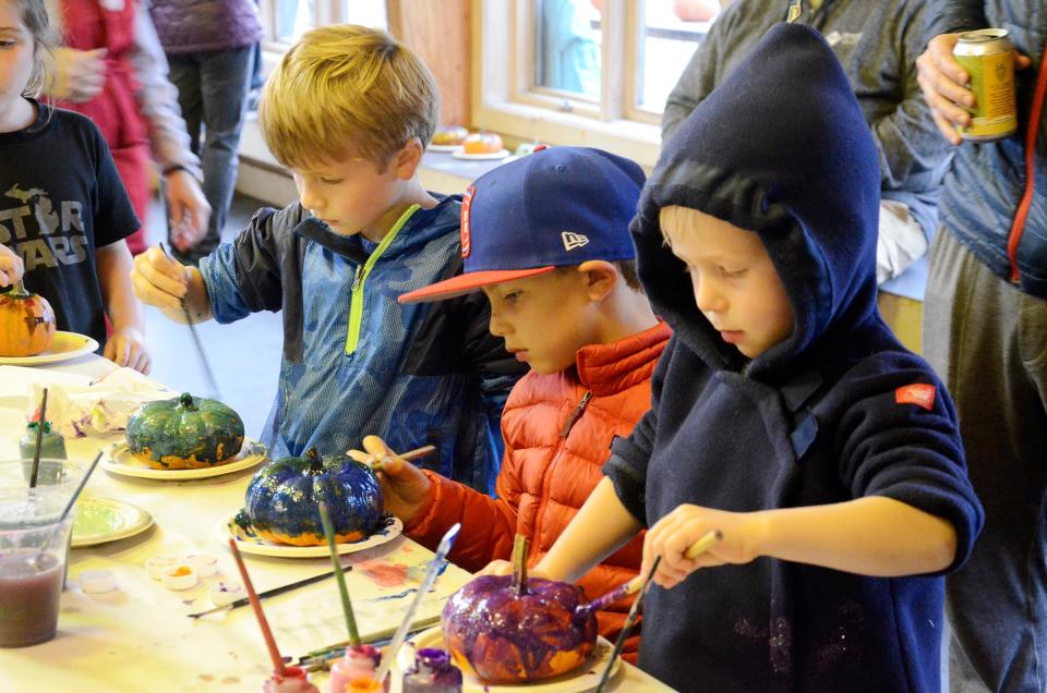 From left) Jack Fisher, Beau Dunn and Teddy Fisher paint pumpkins during the Rotary Club of Petoskey's 2021 Fall Fest at the Winter Sports Park.