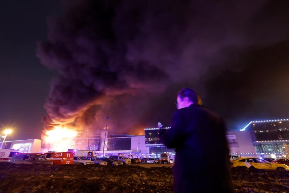 Smoke rises from the building as emergency services try to contain the blaze (Reuters)