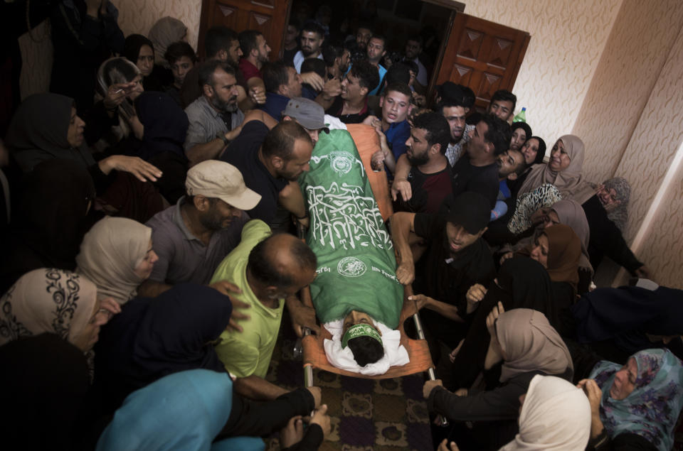 Relatives of 12-year-old Palestinian boy, Fares Sersawi, who was killed by Israeli troops on Friday's protest at the Gaza Strip's border with Israel, mourn around his body at the family home during his funeral in Gaza City, Saturday, Oct. 6, 2018. (AP Photo/Khalil Hamra)