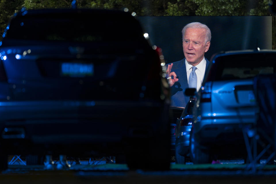 Audience members watch from their cars as Democratic presidential candidate former Vice President Joe Biden, seen on a large monitor, speaks during a CNN town hall moderated by Anderson Cooper in Moosic, Pa., Thursday, Sept. 17, 2020. (AP Photo/Carolyn Kaster)