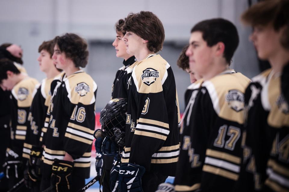 St. Paul's Colin Kreuz, center, stands with his team for the national anthem Saturday night at Buffone Arena.