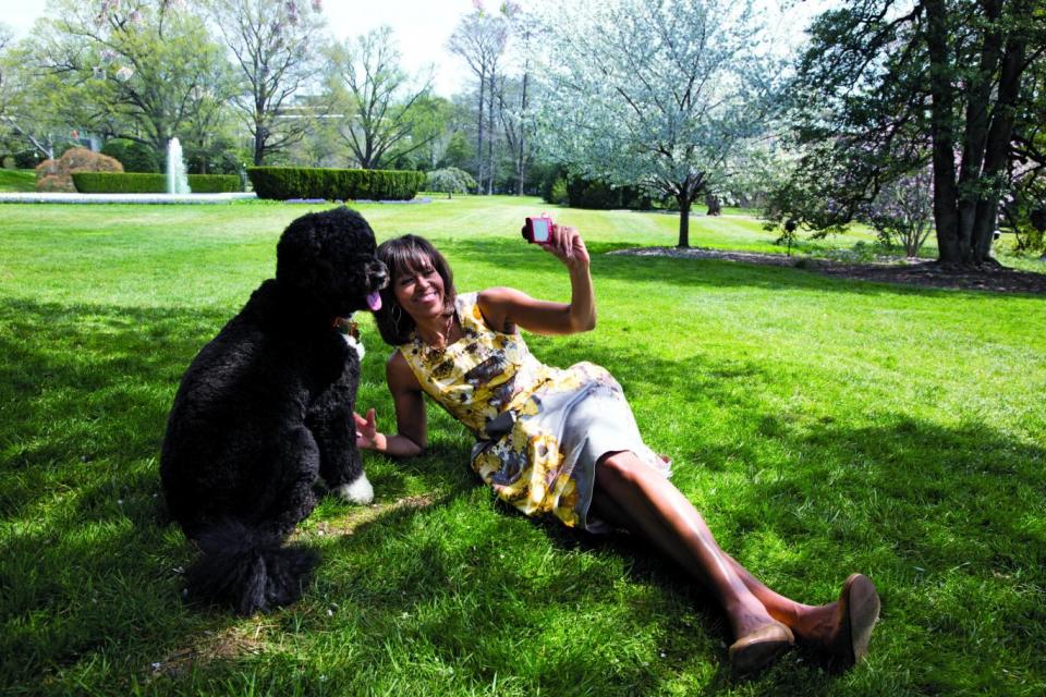 Michelle Obama takes a photograph of Bo, the Obama family dog, in the White House Kitchen Garden, April 11, 2013 (Official White House Photo by Chuck Kennedy)