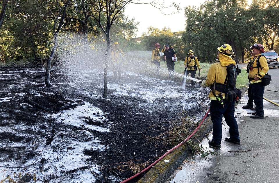 Redding firefighters extinguish a small vegetation fire along Quartz Hill Road near Lake Redding Park on Thursday evening, Aug. 11, 2022.