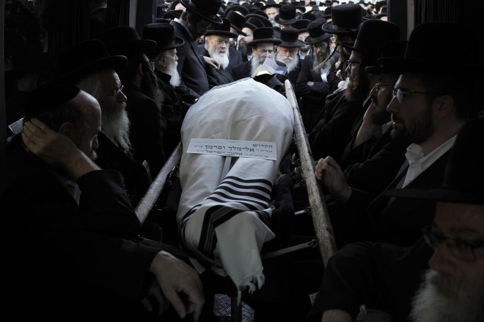 Ultra-Orthodox Jewish men gather around the body of Rabbi Elimelech Wasserman during his funeral in Jerusalem, Thursday, Nov. 30, 2023. Wasserman and at least two other people were killed and several others wounded in a shooting attack in Jerusalem carried out by a pair of Palestinian gunmen that the Hamas militant group claimed as members. Police said the two attackers from east Jerusalem were killed. (AP Photo/Leo Correa)