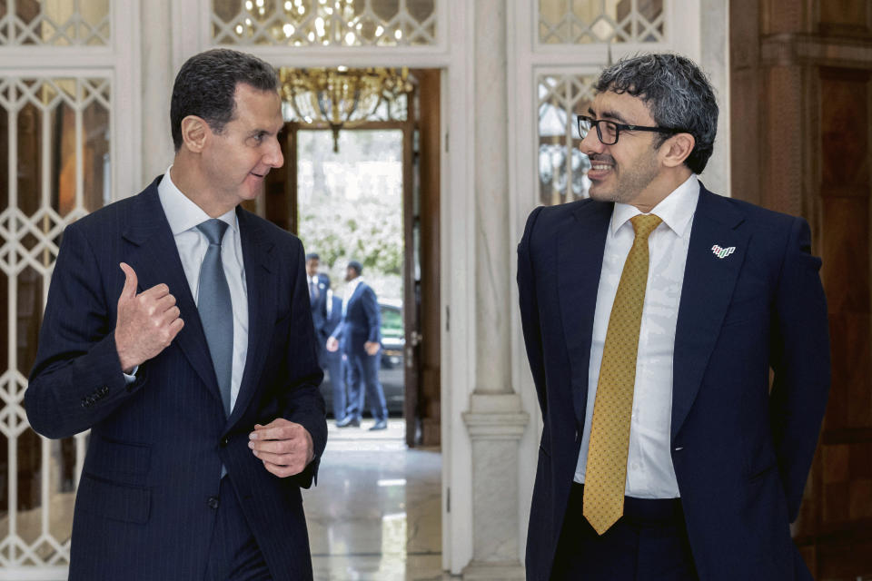 In this photo released by the official Syrian state news agency SANA, Syrian President Bashar Assad, left, speaks with United Arab Emirates Foreign Minister Sheikh Abdullah bin Zayed bin Sultan al-Nahyan in Damascus, Syria, Wednesday, Jan. 4, 2023. Sheikh Abdullah bin Zayed Al Nahyan and Assad discussed boosting economic ties between the two countries, according to a statement from Assad's office. (SANA via AP)