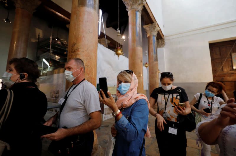 Tourists wearing masks as a preventive measure against the coronavirus visit the Church of the Nativity in Bethlehem in the Israeli-occupied West Bank