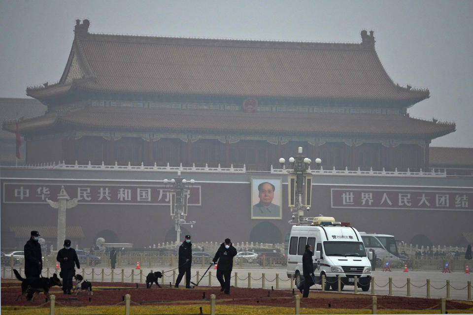 Police officers use sniffer dogs to check on Tiananmen Square before delegates arrive for the opening session of China's National People's Congress (NPC) at the Great Hall of the People in Beijing, Friday, March 5, 2021. China’s No. 2 leader has set a healthy economic growth target and vowed to make this nation self-reliant in technology amid tension with Washington and Europe over trade and human rights. (AP Photo/Andy Wong)