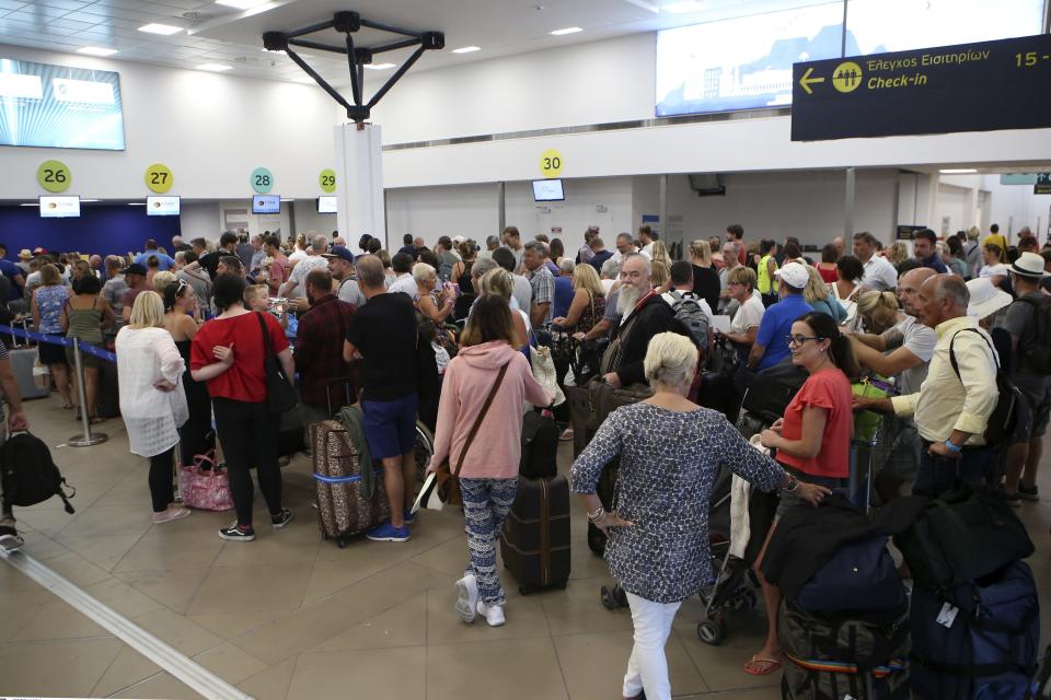 British tourists wait in a queue at the Ioannis Kapodistrias Airport in Corfu island, northwestern Greece, Monday, Sept. 23, 2019. Hundreds of thousands of travelers were stranded across the world Monday after British tour company Thomas Cook collapsed, immediately halting almost all its flights and hotel services and laying off all its employees. (Stamatis Katopodis/InTime News via AP)