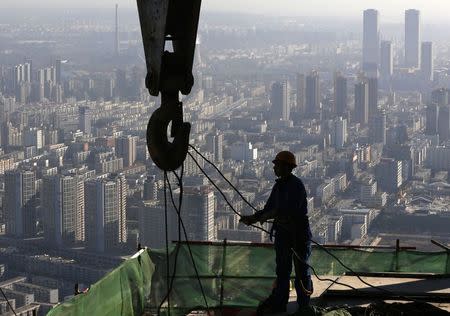 A worker operates at a construction site on the 68th storey of a building in Shenyang, Liaoning province, October 16, 2014. REUTERS/Stringer
