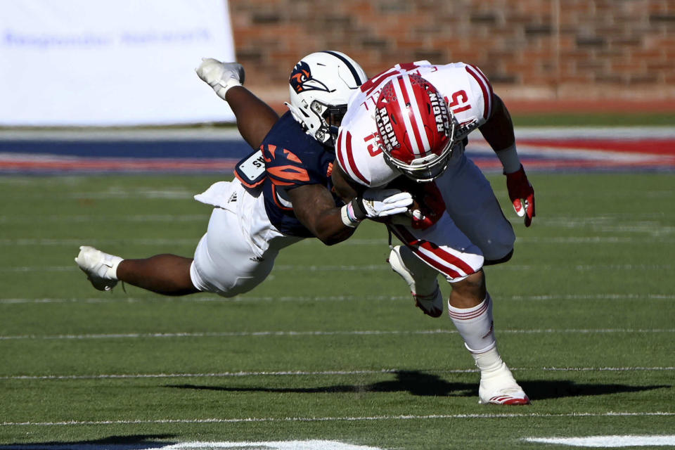 Louisiana-Lafayette running back Elijah Mitchell (15) runs through a tackle attempt by UTSA safety Rashad Wisdom in the first quarter during the First Responder Bowl NCAA college football game in Dallas, Saturday, Dec. 26, 2020. (AP Photo/Matt Strasen)