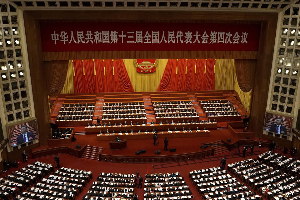 With screens showing Chinese President Xi Jinping, delegates attend the opening session of China's National People's Congress (NPC) at the Great Hall of the People in Beijing on Friday, March 5, 2021. The U.S. sanctioned an additional 24 Chinese and Hong Kong officials over Beijing's ongoing crackdown on political freedoms in the semi-autonomous city, including a decision to overhaul Hong Kong's electoral system. (AP Photo/Andy Wong)