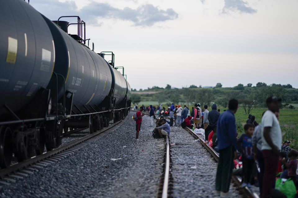 Migrantes ven pasar un tren mientras esperan a lo largo de las vías con la esperanza de subir a un tren de carga que vaya hacia el norte, el 19 de septiembre de 2023, en Huehuetoca, México. (AP Foto/Eduardo Verdugo)