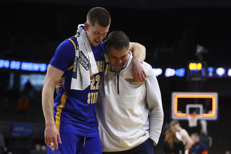 Morehead State guard Riley Minix (22) walks off the court with head coach Preston Spradlin after a 85-69 loss to Illinois in a first-round college basketball game in the NCAA Tournament, Thursday, March 21, 2024, in Omaha, Neb. (AP Photo/John Peterson)
