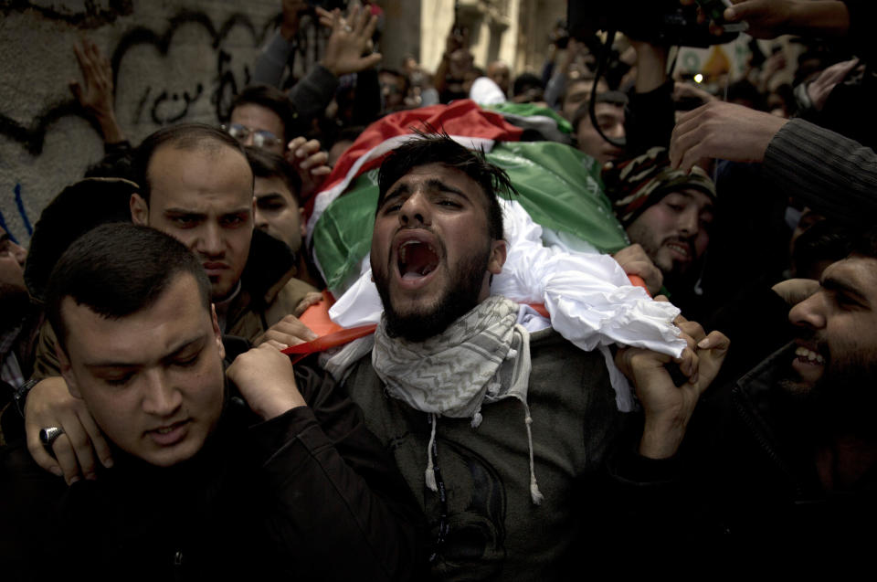 FILE - Palestinians carry the body of Tamir Abu al-Khair, 17, who was shot and killed by Israeli troops during a protest next to the Israeli border, eastern Gaza Strip, out of the family home during his funeral in Gaza City, Sunday, March 31, 2019. Rights groups said Thursday. Dec. 2, 2021, that Israel failed to investigate shootings that killed more than 200 Palestinians and wounded thousands at violent protests along the Gaza frontier in recent years, strengthening the case for the International Criminal Court to intervene. (AP Photo/Khalil Hamra, File)