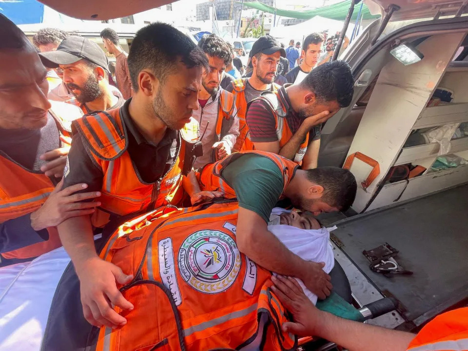 Members of a Palestinian civil emergency team at Shifa Hospital in Gaza City on Monday with the body of a colleague who was killed in an Israeli strike. 