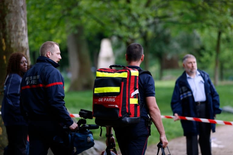 Firefigthers walk at the entrance of the Parc Monceau on May 28, 2016 in Paris, after eleven people including 10 children were struck by lightning in the parc