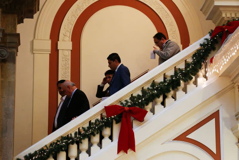 Ministers of interim President Jeanine Anez cabinet walk down a flight of stairs at the presidential palace in La Paz