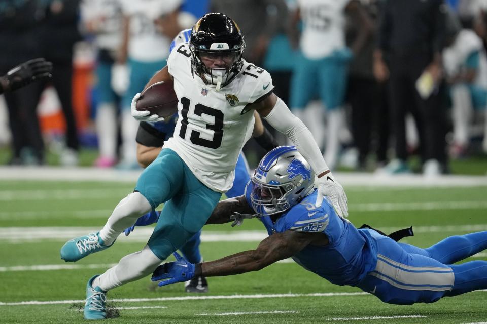Jacksonville Jaguars wide receiver Christian Kirk (13) evades Detroit Lions safety DeShon Elliott (5) during the second half of an NFL football game, Sunday, Dec. 4, 2022, in Detroit. (AP Photo/Paul Sancya)