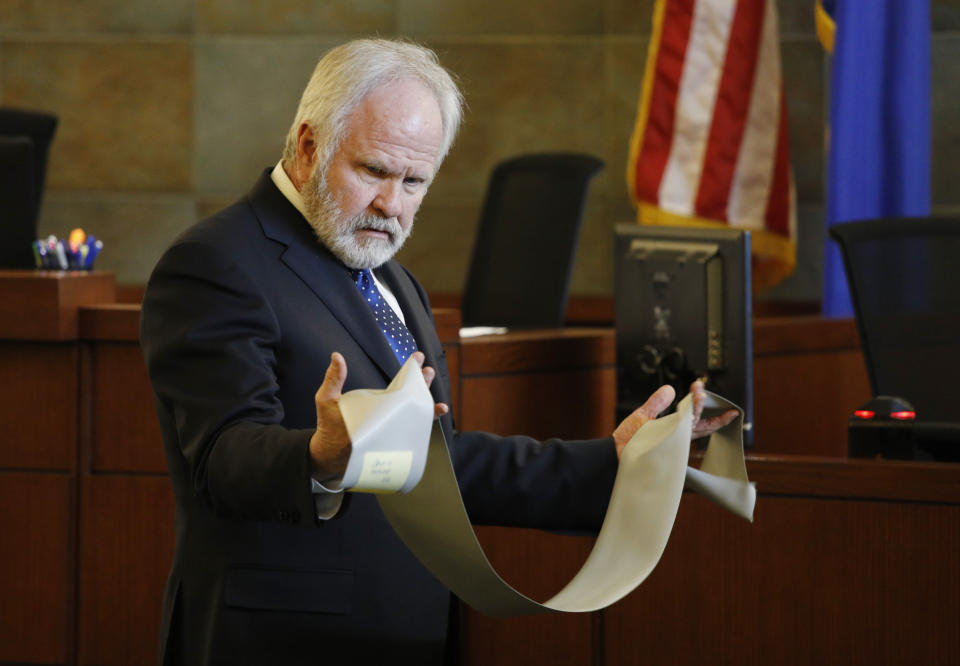 James L. Wilkes II, attorney for former U.S. Sen. Harry Reid, holds a rubber exercise band in court Tuesday, March 26, 2019, in Las Vegas. A jury in Nevada heard opening arguments Tuesday in Reid's lawsuit against the maker of a flexible exercise band that he says slipped from his hand while he used it in January 2015, causing him to fall and suffer lasting injuries including blindness in one eye. (AP Photo/John Locher)