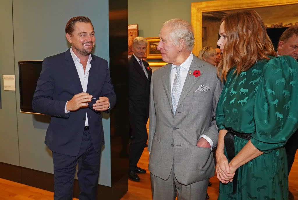 The Prince of Wales (centre) speaks with designer Stella McCartney (right) and Leonardo DiCaprio (left) as he views a fashion installation by the designer, at the Kelvingrove Art Gallery and Museum, during Cop26 (PA) (PA Wire)