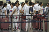 North Koreans line up to check in for a flight to Astana at the Capital Airport in Beijing, Friday, Aug. 18, 2023. A team of North Korean Taekwondo athletes are reportedly travelling via China to Astana, capital of Kazakhstan, to compete in a Taekwondo competition. (AP Photo/Ng Han Guan)